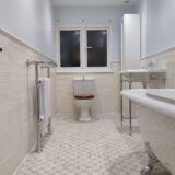 Traditional toilet, patterned bathroom floor, basin on leg stand, freestanding radiator and bath