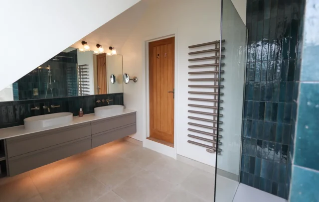 Deep blues & warm neutrals 🫧 

This recent bathroom renovation was all about balancing unique design with everyday practicality.

The scheme centres around a bespoke floating double vanity in a stone finish, featuring open shelving and downlighting, paired with countertop basins and wall-mounted brushed nickel brassware. 

A full-width made-to-measure mirror enhances the sense of space, while rich glazed blue mitred tiles across the vanity splashback and walk-in shower bring depth, texture and character to the room.

A spacious walk-in shower with LED-lit niches adds both practicality and a subtle design feature, complemented by a cappuccino-toned heated towel rail that ties into the warm neutral palette.

Designed, supplied and installed by our in-house team.

Need help with a bathroom project? Get in touch with our team: 

📞 01959 523 008
🌐 https://www.olympusbathrooms.co.uk/
 📧 info@olympusbathrooms.co.uk   

#luxurybathroomdesign #bathroominstallation #bathroominspiration #bathroomtiles